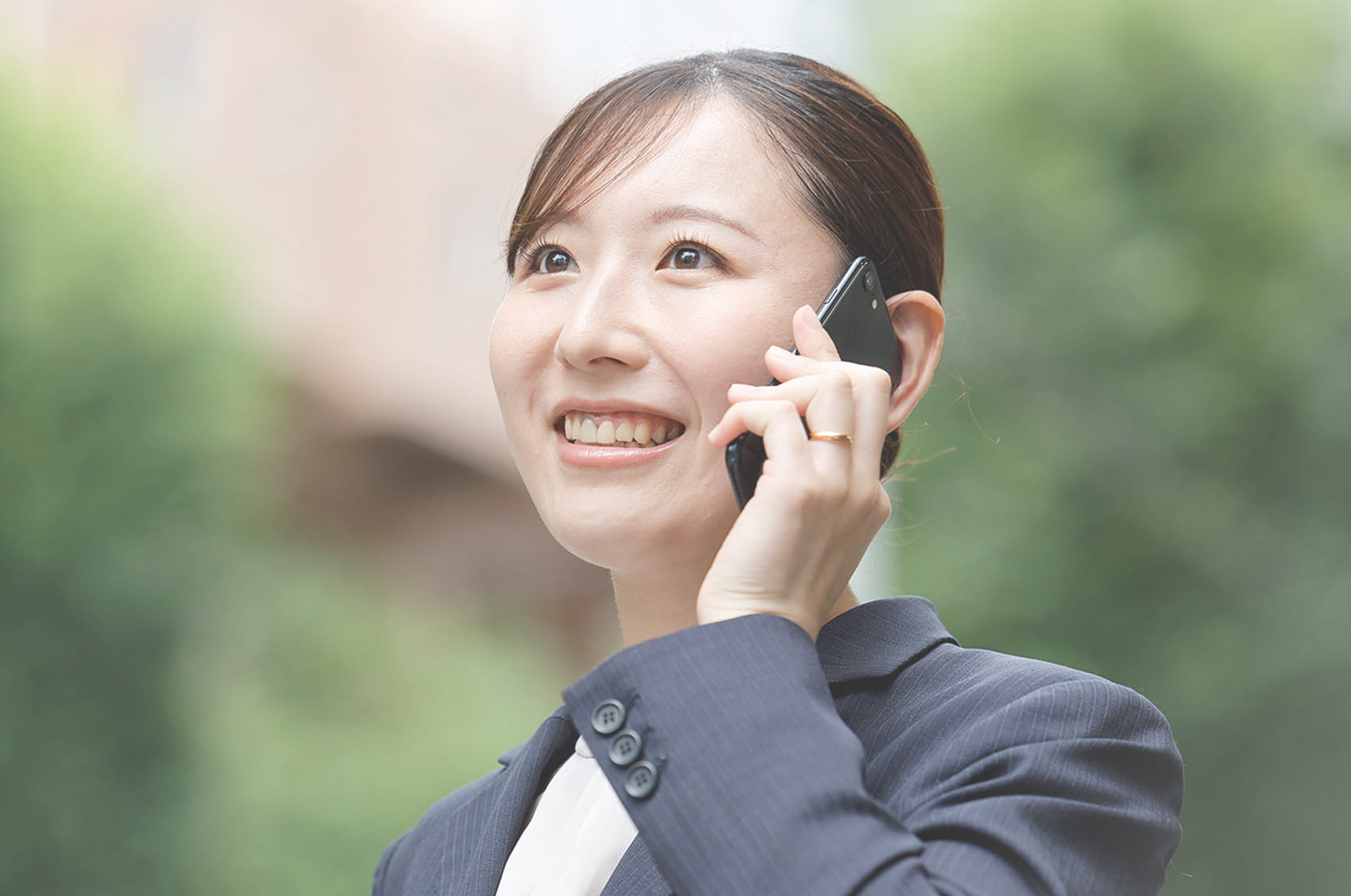 スマートフォンで通話するスーツ姿の女性