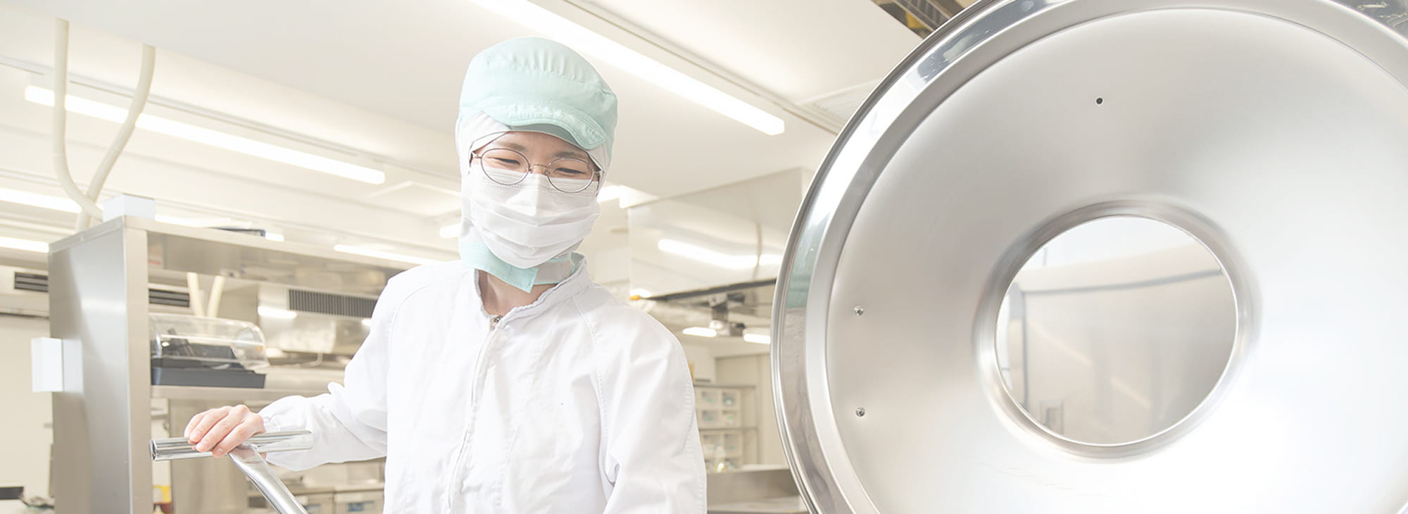 衛生管理された工場で大型機械を操作する作業員