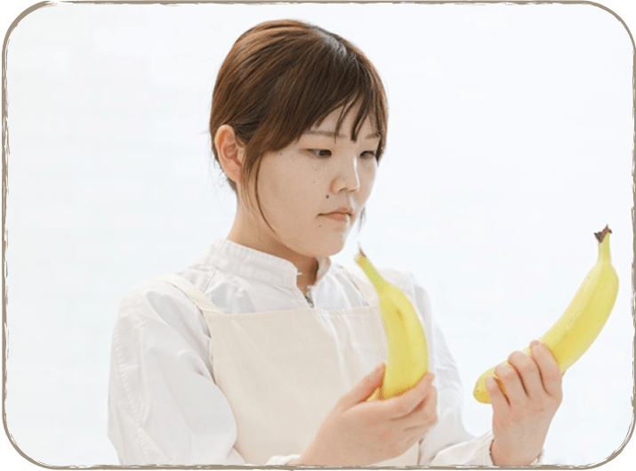 女性が2本のバナナを持っている様子。